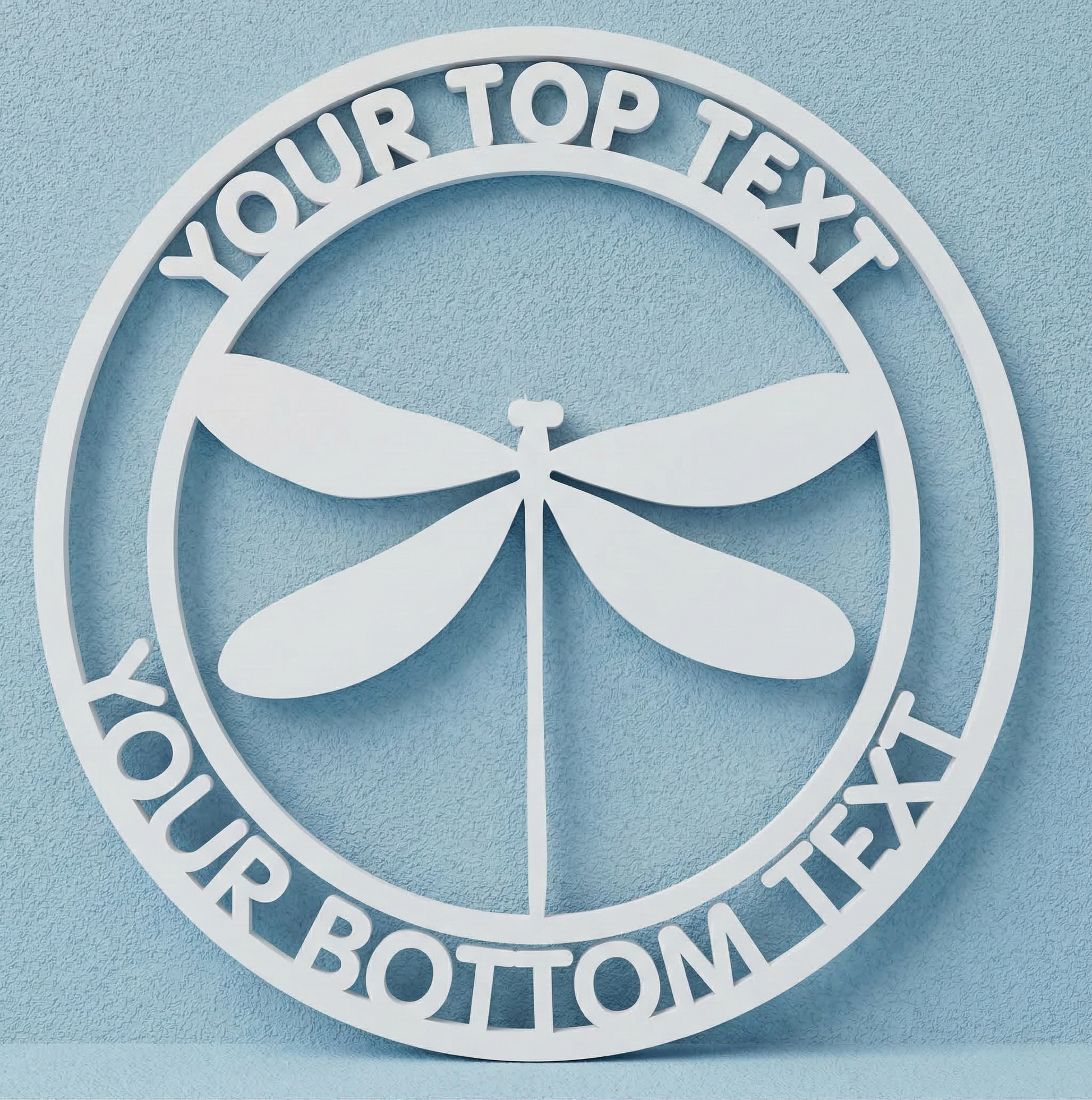 Decorative wall art with a dragonfly design and customizable text on a light blue background